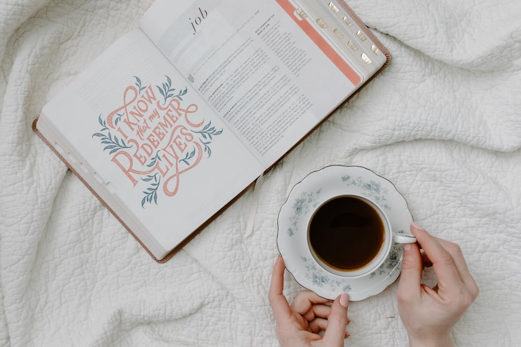 A Person Having Coffee While Reading a Book